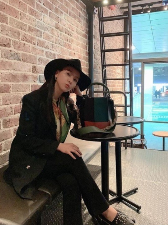 Kim posa en una silla de café